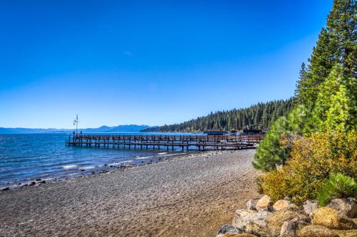 a beach with a pier and water and trees at Totally Tahoe Townhome in Crystal Bay