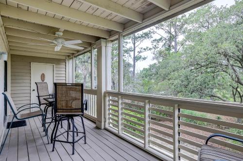 a screened porch with chairs and a ceiling fan at Bend in the Road 2003 in Seabrook Island