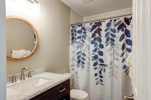 a bathroom with a sink and a toilet and a shower curtain at Bend in the Road 2003 in Seabrook Island