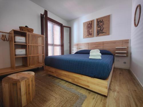 une chambre avec un lit bleu et une fenêtre dans l'établissement Kefalure, à Cefalù