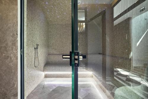 a bathroom with a shower with a glass door at La Fleur Boutique Hotel in Tivat