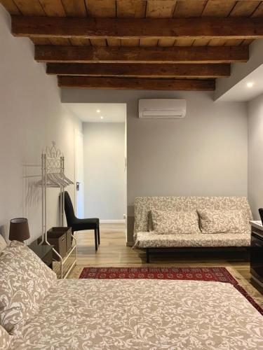 a bedroom with a bed and a couch and a chair at Al Vecchio CIVICO 1 in Stellanello