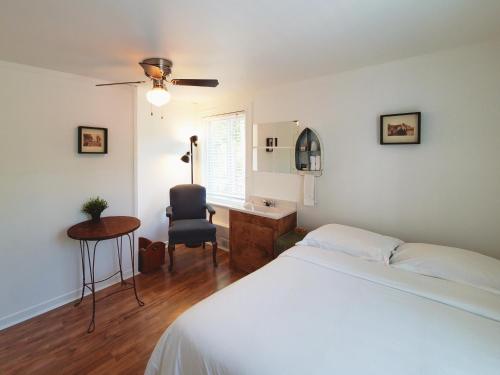 a bedroom with a bed and a desk and a chair at Auberge de la rive de Charlevoix - Auberge de jeunesse familiale pour voyageurs de tous âges in Saint-Joseph-de-la-Rive