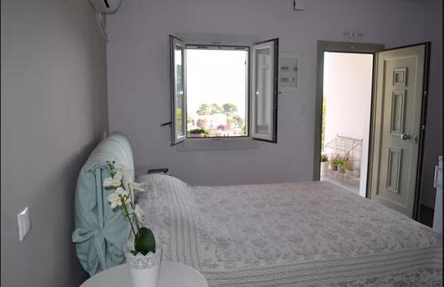 a white bedroom with a bed and a window at Romanza Studios in Asos