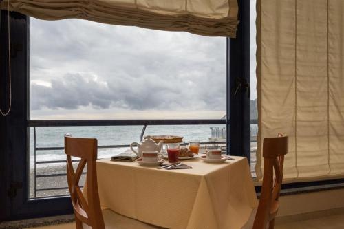 a table with a view of the ocean from a window at Hotel 4 Venti spa & wellness in Sestri Levante