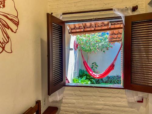 a window with a hammock in a room at Pousada Atlantis in Jericoacoara