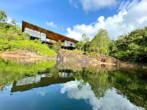 a building on the side of a river at Kurunduketiya Private Rainforest Resort in Kalawana