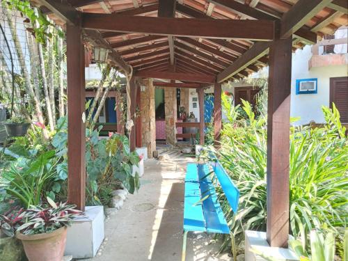 a wooden pergola with blue chairs in a garden at Pousada Brasil Paraty in Paraty