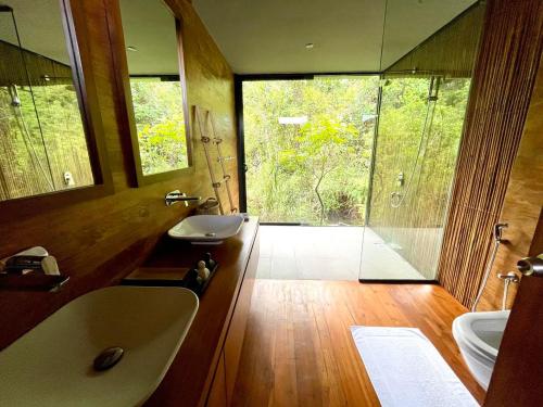 a bathroom with a tub and a sink and a mirror at Kurunduketiya Private Rainforest Resort in Kalawana