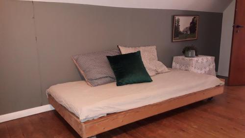 Una cama con una almohada verde encima. en Lundtofthøj en Åbenrå