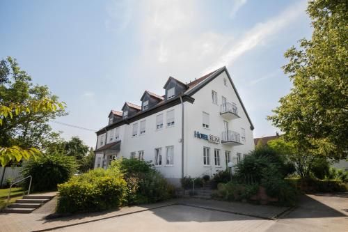 a white building with a lot of plants in front of it at Gasthof Linde - Hotel Blum in Unterroth