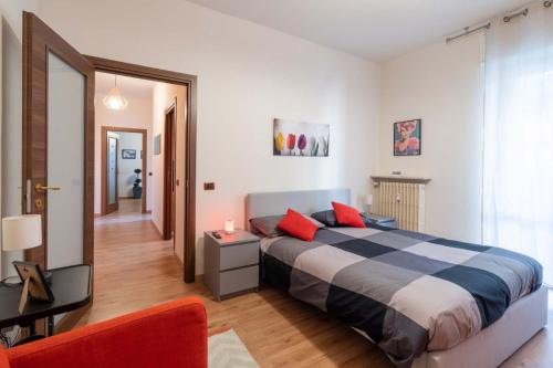 - une chambre avec un grand lit et une chaise rouge dans l'établissement Casa Martina- Airport free shuttle-H24, à Bergame