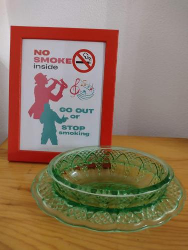 a glass bowl on a table next to a no smoke inside sign at sax & rosa in Pigna