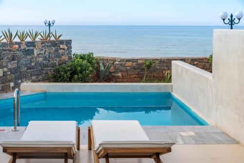a swimming pool with a view of the ocean at The Island Hotel - Adults Only - in Gouves