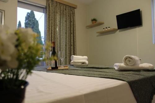 una camera d'albergo con un letto con asciugamani e una finestra di Studio Nefeli a Archangelos