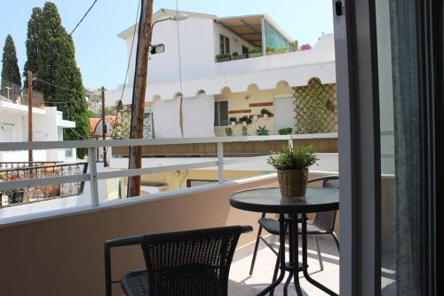 un balcone con tavolo e sedie e vista su un edificio di Studio Nefeli a Archangelos