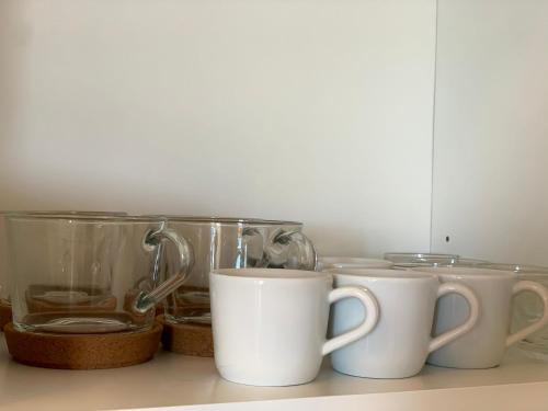 a row of coffee cups sitting on a shelf at AL PEPE NERO - Casa in campagna a soli 5 minuti dal mare in Polignano a Mare