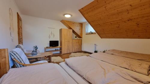 a bedroom with two beds and a table with a tv at Chalupa Staré polesí in Karolinka