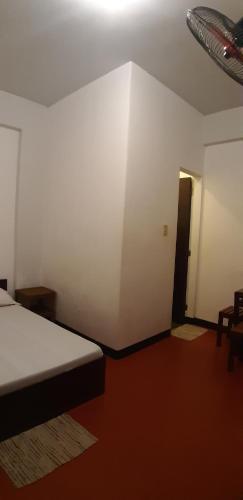 een slaapkamer met een bed en een kamer met een deur bij Angel and Marie's Basic FANroom for 1 - 2 pax in Dalumpinas Oeste