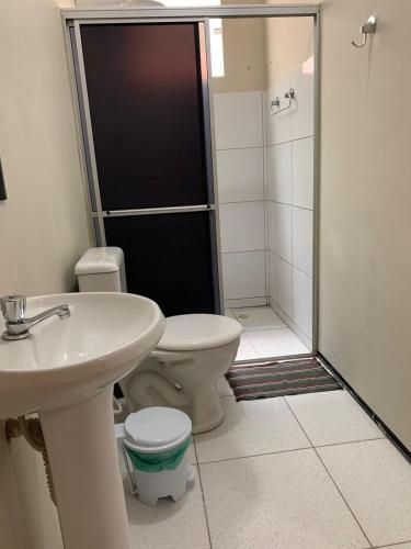 a bathroom with a shower and a toilet and a sink at Residencial Milagre 202 in Juazeiro do Norte