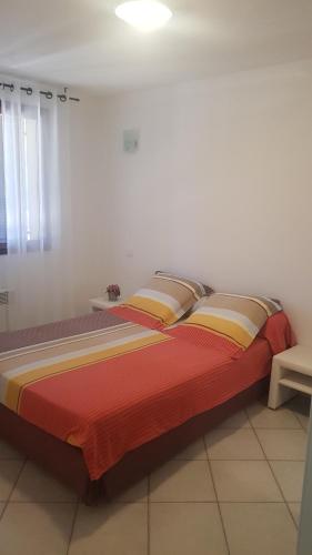 - une chambre avec un grand lit et une couverture rouge dans l'établissement Bas de Villa chez Mr.Girolami Dominique, à Bastia