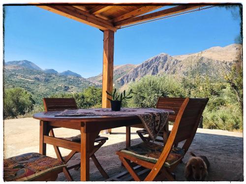 - une table et des chaises sur une terrasse couverte offrant une vue sur les montagnes dans l'établissement Casa DiEle, à Castelbuono