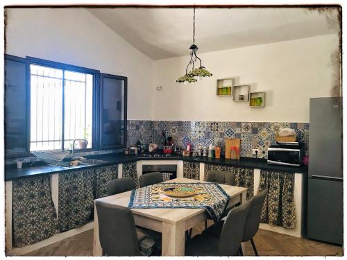 une cuisine avec une table, des chaises et une table ainsi qu'une salle à manger dans l'établissement Casa DiEle, à Castelbuono