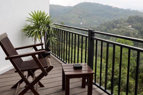 a chair and a table on a balcony with a plant at Riverbank Resort Gampola in Gampola