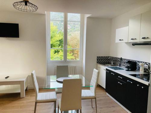 - une cuisine et une salle à manger avec une table et des chaises dans l'établissement Charmant appartement dans une magnifique résidence, à Sospel