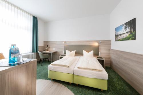 a hotel room with a bed and a desk at Hotel Reichshof garni in Schwerte
