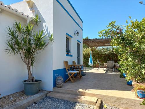 - une terrasse dans une maison avec une table et des chaises dans l'établissement Monte da Caldeirinha, à Luz de Tavira