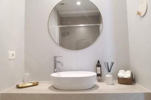 a white bathroom with a sink and a mirror at Vicolo Fiore Affittacamere II in Matera