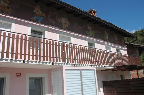 ein rosa und weißes Haus mit einem Balkon in der Unterkunft Mike's Rooms in Kobarid