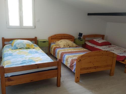 sypialnia z dwoma łóżkami i dwoma krzesłami w obiekcie Gîte paisible rénové w mieście Hagetmau