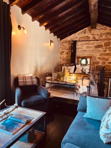 a living room with a blue couch and a table at Palheiro Mezio in Mezio