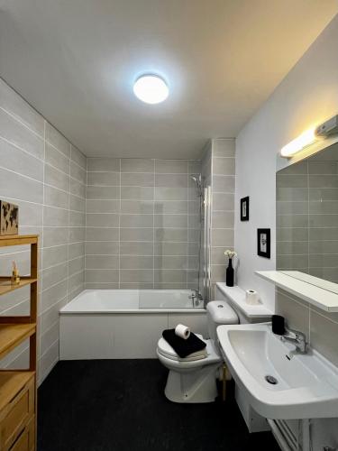 une salle de bain avec une baignoire, des toilettes et un lavabo dans l'établissement Superbe appartement confortable, proche centre ville, à Rennes