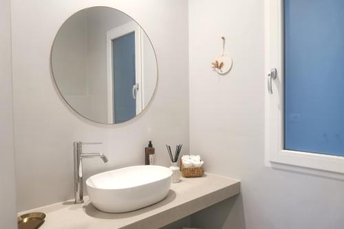 a white bathroom with a sink and a mirror at Vicolo Fiore Affittacamere II in Matera