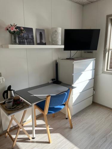 a desk with a chair and a table with a tv at Pavillon Greve in Greve