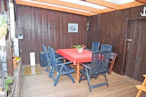 a red table and chairs on a patio at Ferienhaeuser im Ostseebad Baabe in Baabe