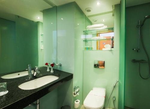 a bathroom with a sink and a shower and a toilet at Ramada Encore By Wyndham Tangier in Tangier