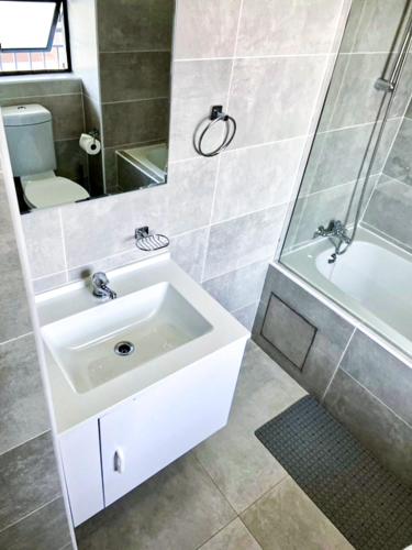 uma casa de banho com um lavatório, um chuveiro e um WC. em 303 Luxury Suite em Gaborone