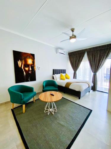 um quarto com uma cama, uma mesa e cadeiras em 303 Luxury Suite em Gaborone