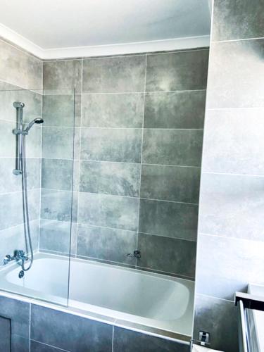 uma casa de banho com um chuveiro e uma banheira em 303 Luxury Suite em Gaborone