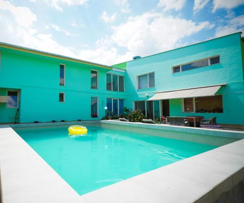 a swimming pool with a yellow frisbee in front of a building at Pensiunea Dolce in Timişoara