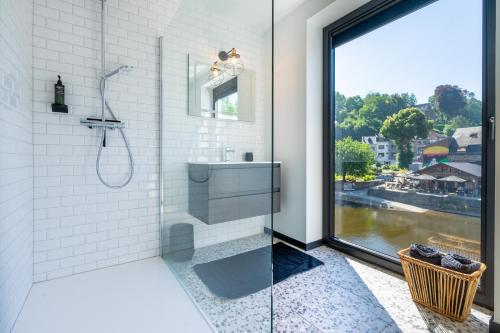 a bathroom with a shower and a sink and a window at La Maison Noire in La Roche-en-Ardenne