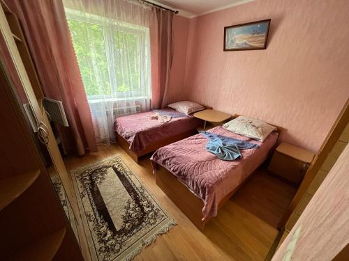 two beds in a small room with a window at Fortuna in Cherche