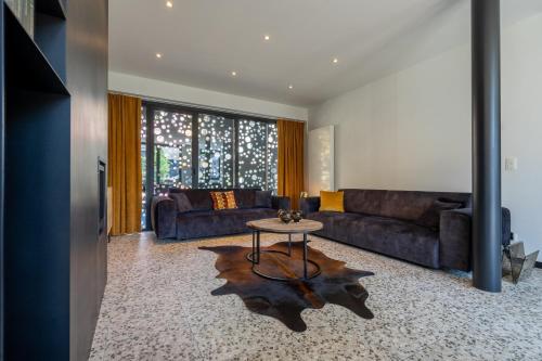a living room with a couch and a table at La Maison Noire in La Roche-en-Ardenne