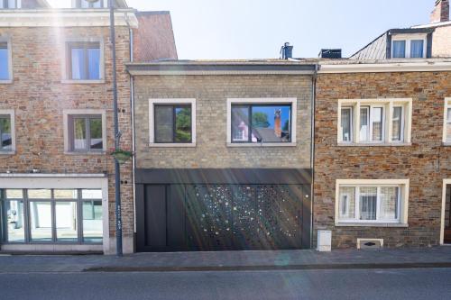 a brick building with a large black garage at La Maison Noire in La Roche-en-Ardenne