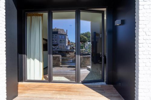 a glass door with a view of a building at La Maison Noire in La Roche-en-Ardenne