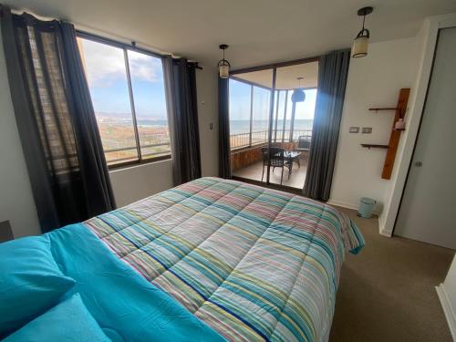een slaapkamer met een bed en een groot raam bij Depto piso 6 frente al mar in Antofagasta